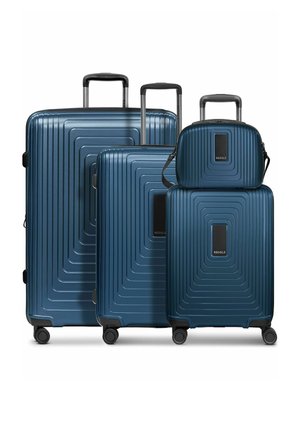 Quattro valigie rigide blu navy con manici telescopici e quattro ruote girevoli, caratterizzate da un motivo geometrico a quadrati sulla superficie.