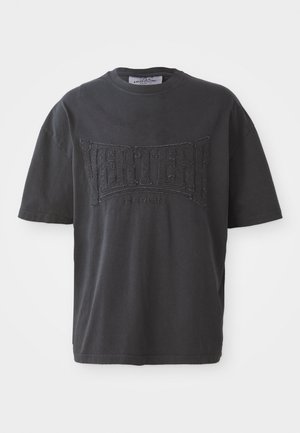 Black cotton t-shirt featuring a textured "VERTERE BERLIN" graphic on the front. Short sleeves and a crew neckline. Casual fit.