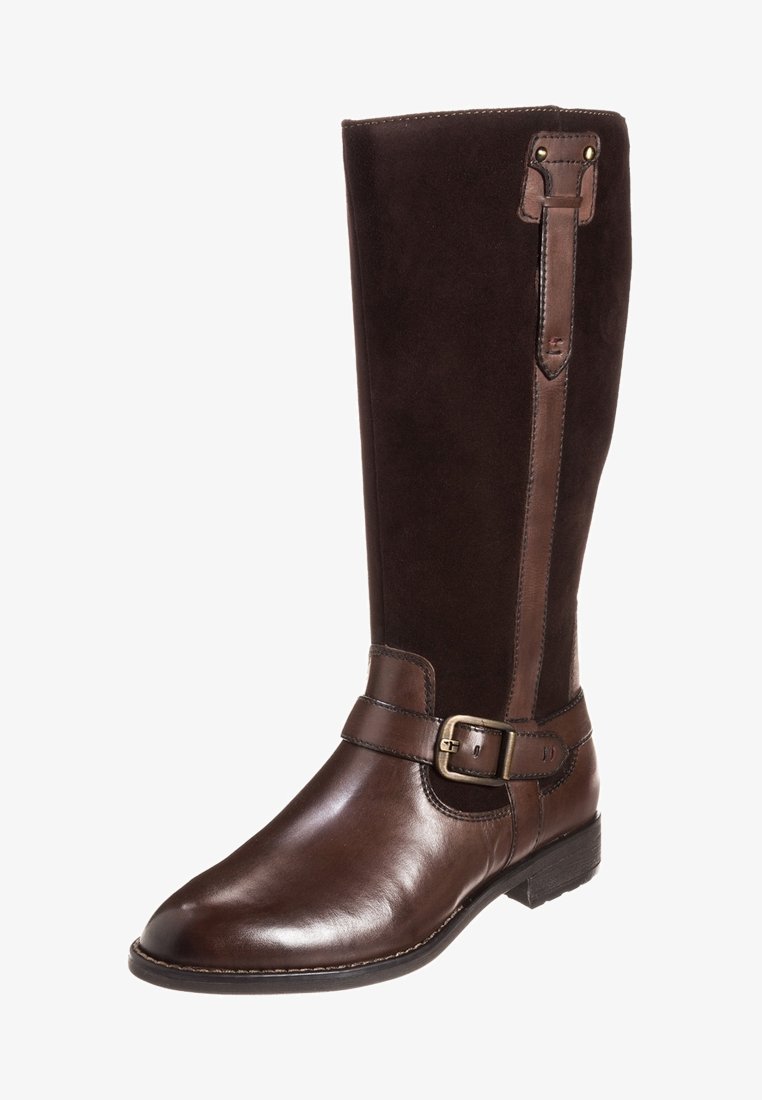 Bota de cuero de color marrón oscuro hasta la rodilla, con pie de cuero liso, caña de ante, correa en el tobillo con hebilla de latón y tacón bajo apilado.