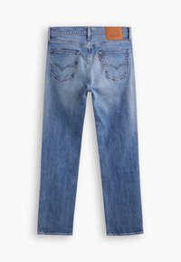Jean en denim bleu vu de dos avec deux poches cousues, passants de ceinture et un patch de marque en cuir marron à la taille.