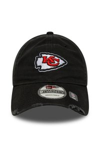 Black adjustable baseball cap with Kansas City Chiefs logo in red and white, featuring slight distress on the bill and branding stickers.