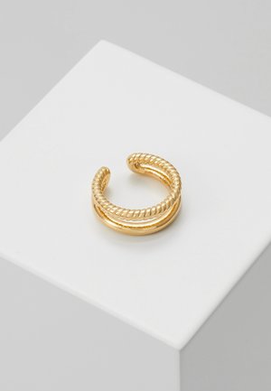 Guld åben dobbeltbåndsring med et glat og et snoet rebtekstureret bånd på hvid pedestal.