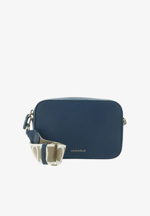 Blauwe rechthoekige schoudertas met een korrelige textuur, een gouden rits en een afneembare beige riem met wit patroon en gouden gespsluiting.