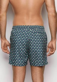 Pantaloni da bagno navy con motivo floreale in rosa e verde. Vita elasticizzata, tessuto leggero e tasche laterali. Vista posteriore mostrata.