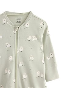 Bebe zeleni zip-up kombinezon s dugim rukavima, prekriven malim bijelim otiscima ovaca i detaljima trave.