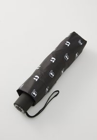 Black roller umbrella with a fabric cover featuring white graphics of various silhouettes. Includes a black handle with a wrist strap.