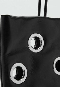 Bolso de mano de cuero negro que presenta tres ojales circulares plateados, con una superficie texturizada y dos correas colgantes para llevar.
