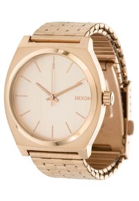 Goldfarbene Armbanduhr mit rundem Gehäuse und minimalistischem Design. Sie verfügt über ein helles Zifferblatt, dünne Stundenmarkierungen und ein strukturiertes Metallarmband.