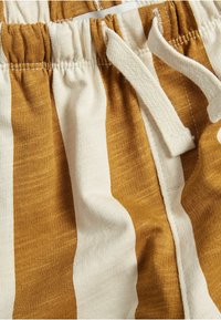 Katoenen shorts met afwisselend mosterdgele en witte strepen. Voorzien van een elastische tailleband met trekkoord en een zachte textuur.