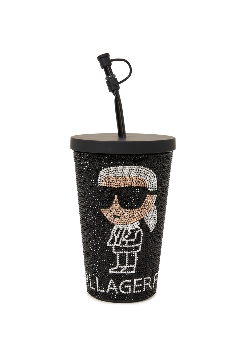 Tasse noire ornée de strass, présentant un personnage de dessin animé avec des lunettes de soleil, un couvercle noir et une paille noire. Le texte indique "KARL LAGERFELD".