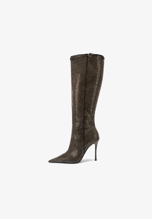 Botte stiletto montée jusqu'au genou en tissu texturé noir et or, avec un bout pointu et une quincaillerie décorative au niveau du talon.