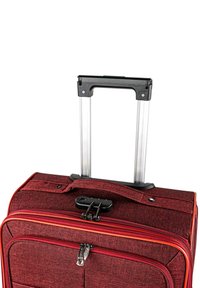 Maleta de tela roja con asa retráctil de aluminio, cremalleras dobles y detalles en negro. Superficie texturizada y ribetes contrastantes.