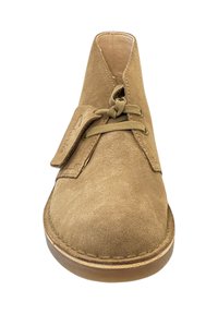 Stivale deserto in suede marrone chiaro con suola spessa, due occhielli, lacci annodati e un'etichetta in pelle marchiata sul lato.