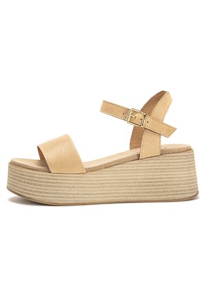 Beige platform-sandaalit, joissa on sileä nahkaremmi, säädettävä nilkkahihna ja teksturoitu uritettu pohja. Rakennettu mukavuutta ja tukea varten.