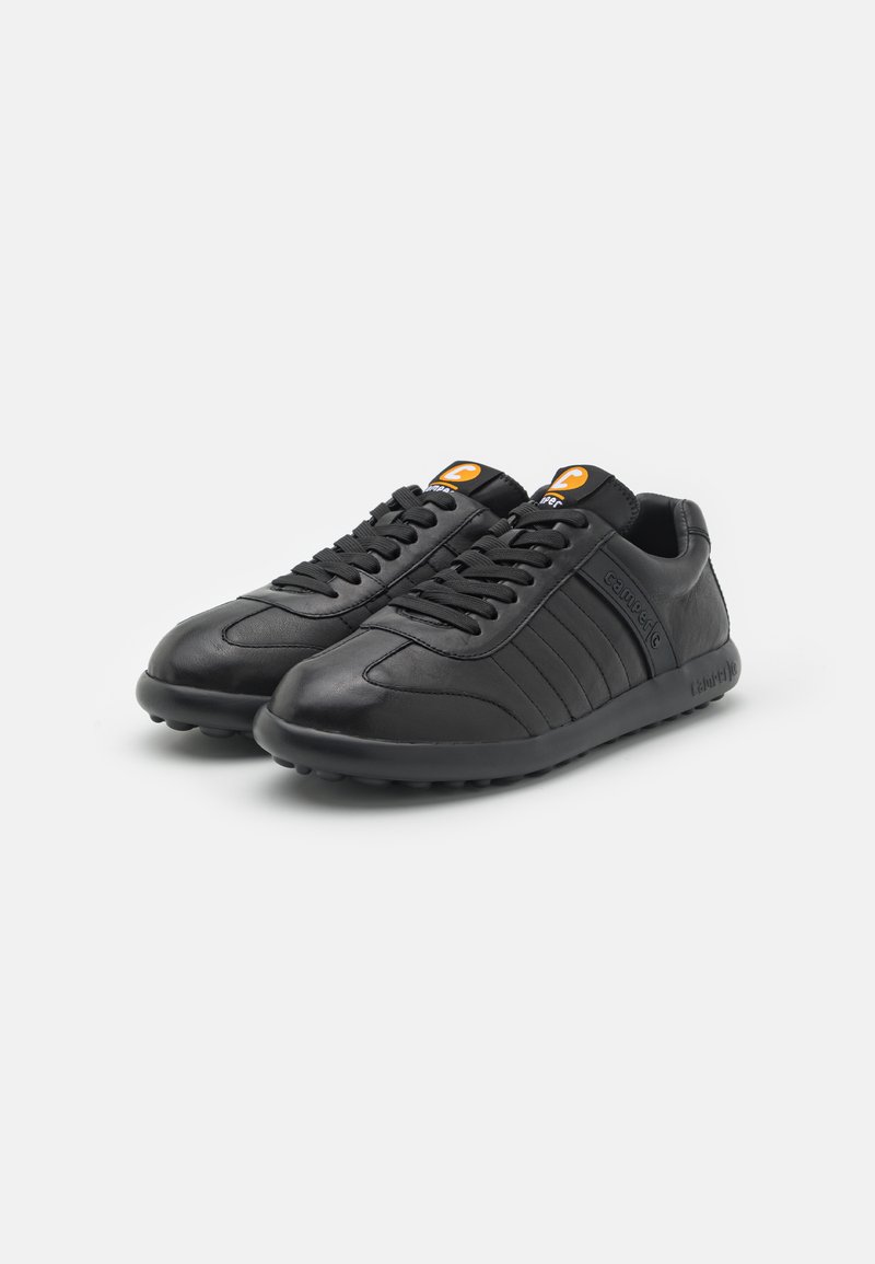 Black sneakers with a smooth leather upper, featuring embossed horizontal stripes, round toe, rubber outsole, and orange logo accents.