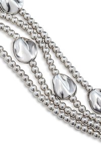 Tres hilos de un collar de cuentas de plata con acentos ovalados pulidos y suaves, y cuentas esféricas, que presentan un acabado metálico brillante.