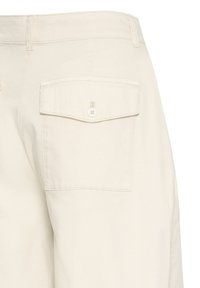 Pantalon beige clair avec une poche arrière à rabat sécurisée par un seul bouton, coutures visibles et passants pour ceinture à la taille.
