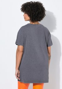 Grå oversized T-shirt med rund halsudskæring og korte ærmer, lavet af blødt bomuld. Har en afslappet pasform og sidespalter for nem bevægelse.