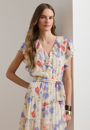 Blomstret kjole med flæseærmer i cremefarve, med røde og blå blomster, bindebånd i taljen og lagdelt nederdel. Glat, let stof.