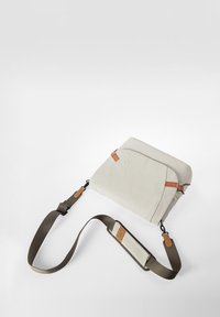 Borsa a tracolla beige con accenti marroni, caratterizzata da una texture liscia, tracolla regolabile e chiusura a patta con dettaglio del logo impresso.