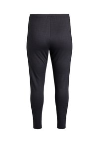 Leggings elásticos negros de tejido liso y texturizado con un diseño ajustado. Cinturilla sin cierres visibles, silueta aerodinámica.