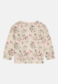 Haut long beige clair à manches longues présentant un motif répété de lapins et de fleurs dans des teintes douces de vert, rose et orange sur une surface texturée.