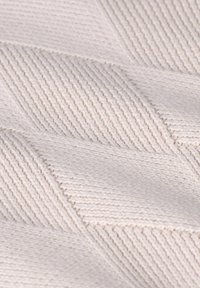 Tissu en tricot texturé dans une teinte beige clair, arborant un motif de losanges en diagonale avec des sections en relief et plates pour une profondeur accrue.