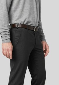 Schiefergraue Hose im Slim-Fit-Schnitt mit Seitentaschen und einem braunen gerippten Gürtel mit einer silbernen Schnalle. Darunter ein weiches graues Hemd.
