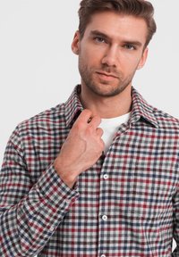 Camicia da uomo in flanella con un motivo a scacchi multicolore in rosso, blu navy e grigio. Presenta un colletto button-down e bottoni bianchi.