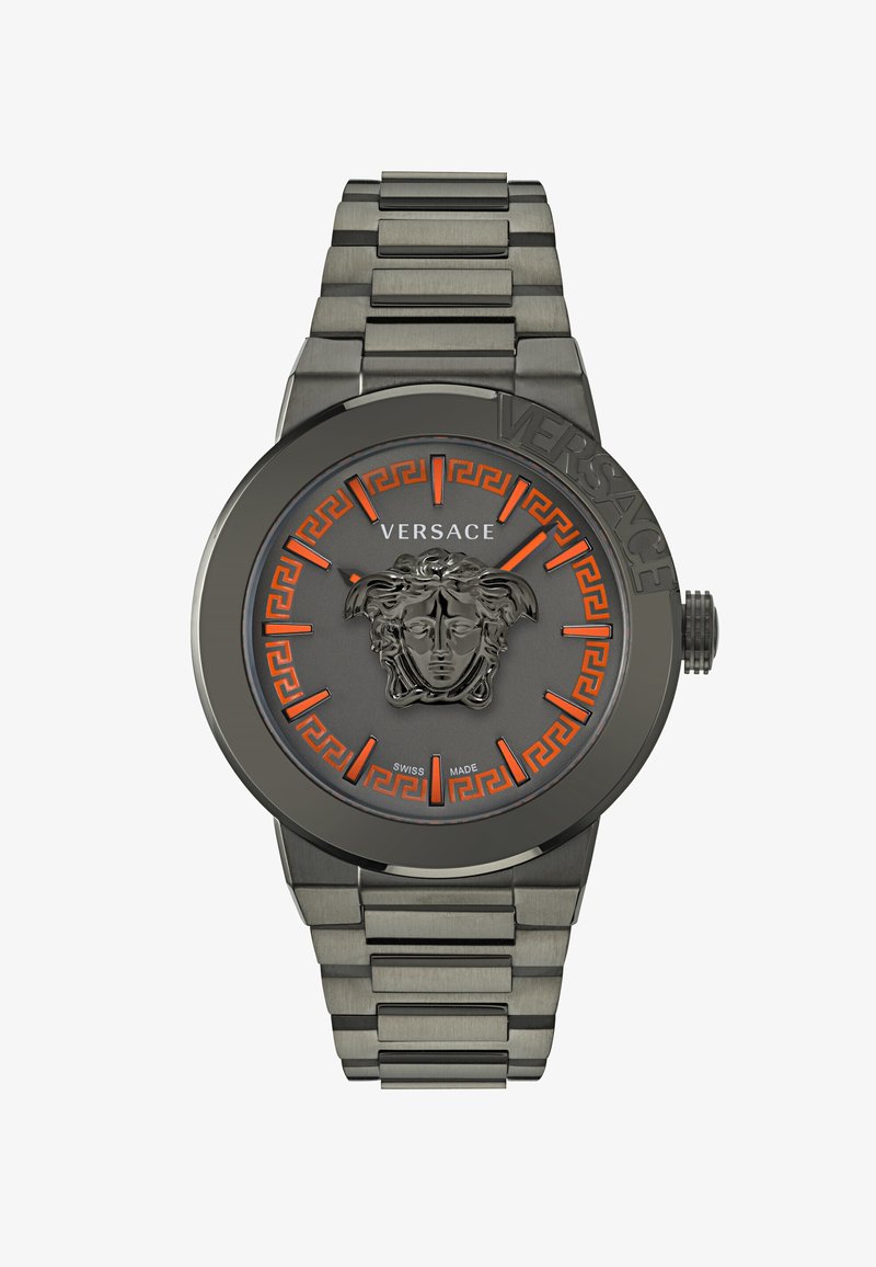 Orologio Versace con quadrante grigio che presenta un emblema Medusa 3D, accenti arancioni, motivo della chiave greca in rilievo e bracciale in acciaio inossidabile.