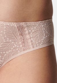 Spitzen-Bikini in sanftem Rosa, mit floralem Muster und zarter Textur. Breiter Spitzenbund mit transparenter Gestaltung, glatte Kanten.