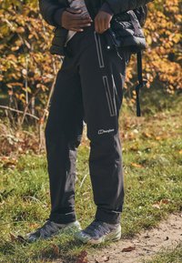 Melnas āra bikses ar rāvējslēdzēja kabatām un pieguļošu dizainu, izgatavotas no izturīga materiāla. Logo redzams uz apakšējās kājas.
