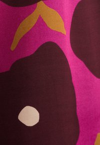 Tessuto audace con grandi forme astratte in rosa, bordeaux e giallo senape, con una texture liscia e una sottile lucentezza.