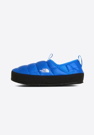 Blue quilted slip-on shoe with black sole and white The North Face logo on the side, designed for casual indoor or outdoor use.