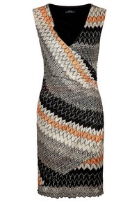 Knytdress med ett zigzag-mönster i svart, vitt och orange. V-ringning, ärmlös design och fransdetaljer vid fållen.