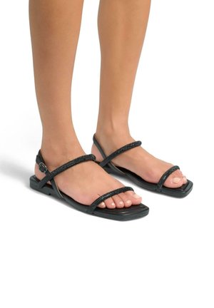 Sandalias planas negras con dos tiras brillantes y un diseño de punta cuadrada, que cuentan con una correa en el tobillo con una pequeña hebilla ajustable.