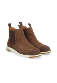 Bottines Chelsea en daim marron avec des panneaux élastiques sur les côtés et des languettes. Semelles en caoutchouc blanc avec une finition texturée. Design à bout rond.