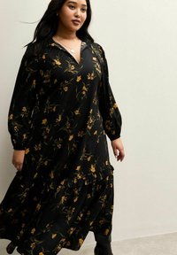 Schwarzes Blumenkleid mit gelben Akzenten, langen Puffärmeln, V-Ausschnitt und gestuftem, gerafftem Saum, gefertigt aus glattem, leichtem Stoff.