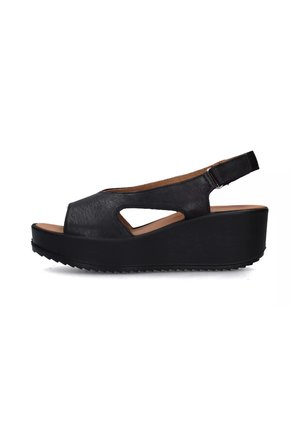 Sandali wedge neri con tomaia in pelle, design con ritagli, cinturino alla caviglia regolabile e suola in gomma texturizzata. Punta aperta e altezza della piattaforma.