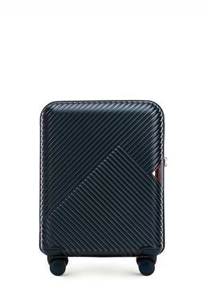 Valise rigide avec texture à rayures diagonales, couleur bleu marine, accents en rose doré, et quatre roues roulantes pour la maniabilité.