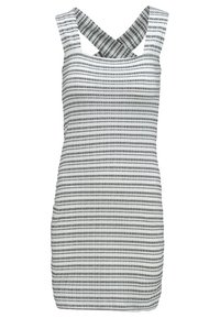 Mouwloze witte jurk met zwart horizontaal streeppatroon, voorzien van brede kruislings gekruiste banden op de rug en een aansluitende silhouet.