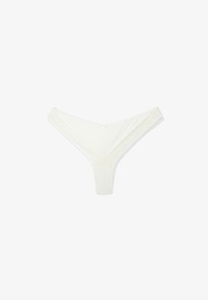 Tanga de encaje blanco con cuerpo de tela suave, con delicados adornos de encaje en los bordes y un pequeño lazo en la cintura.