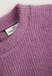 Fioletowy sweter dziergany o prążkowanej fakturze. Posiada okrągły dekolt i subtelny połysk dzięki akcentom z nitki. Metka z napisem "CDRL COCCO".