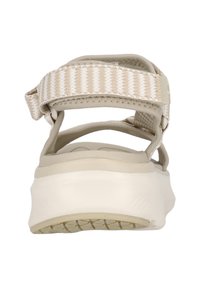 Beige sandaler med en bred remdesign, texturerad tyg och en vadderad vit sula. Justerbar bakrem för en säker passform.