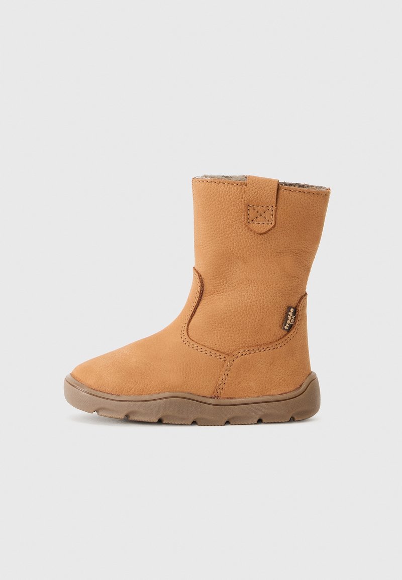 Botte en cuir beige jusqu'au milieu du mollet avec doublure en fourrure, semelle en caoutchouc plate et languette de traction sur un fond gris clair uni.
