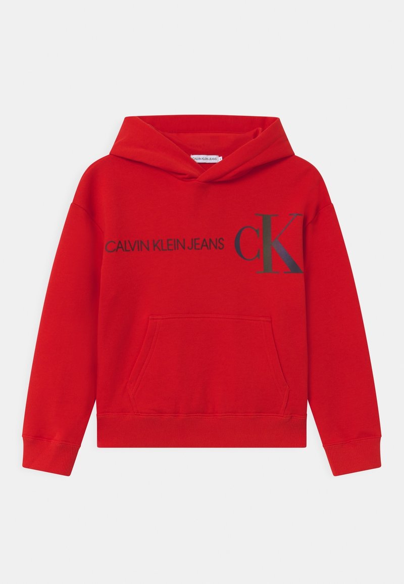 Sweat-shirt à capuche rouge avec poche avant, featuring "CALVIN KLEIN JEANS" et le logo "CK" en imprimé noir contrasté. Tissu doux, poignets côtelés.