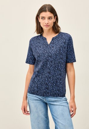 Camisa de manga corta azul marino con un patrón de hojas, con escote en V y un corte relajado. Fabricada en un tejido ligero, adecuada para el uso casual.