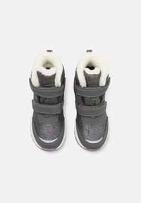 Szürke csillogó magas szárú sneaker, fehér műszőrme béléssel, tépőzáras pántokkal és fehér talppal. Jellemzője a sima textúra és a tartós kivitel.