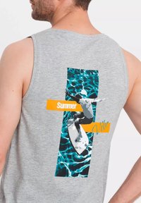 Šedé tričko bez rukávů s barevným grafikou surfaře na prkně a textem "Letní atmosféra" v oranžových a modrých akcenty.