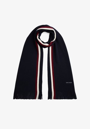 Bufanda azul marino con rayas rojas, blancas y azul marino a lo largo de los bordes, con extremos con flecos y pequeño parche rectangular con el logo de Tommy Hilfiger.